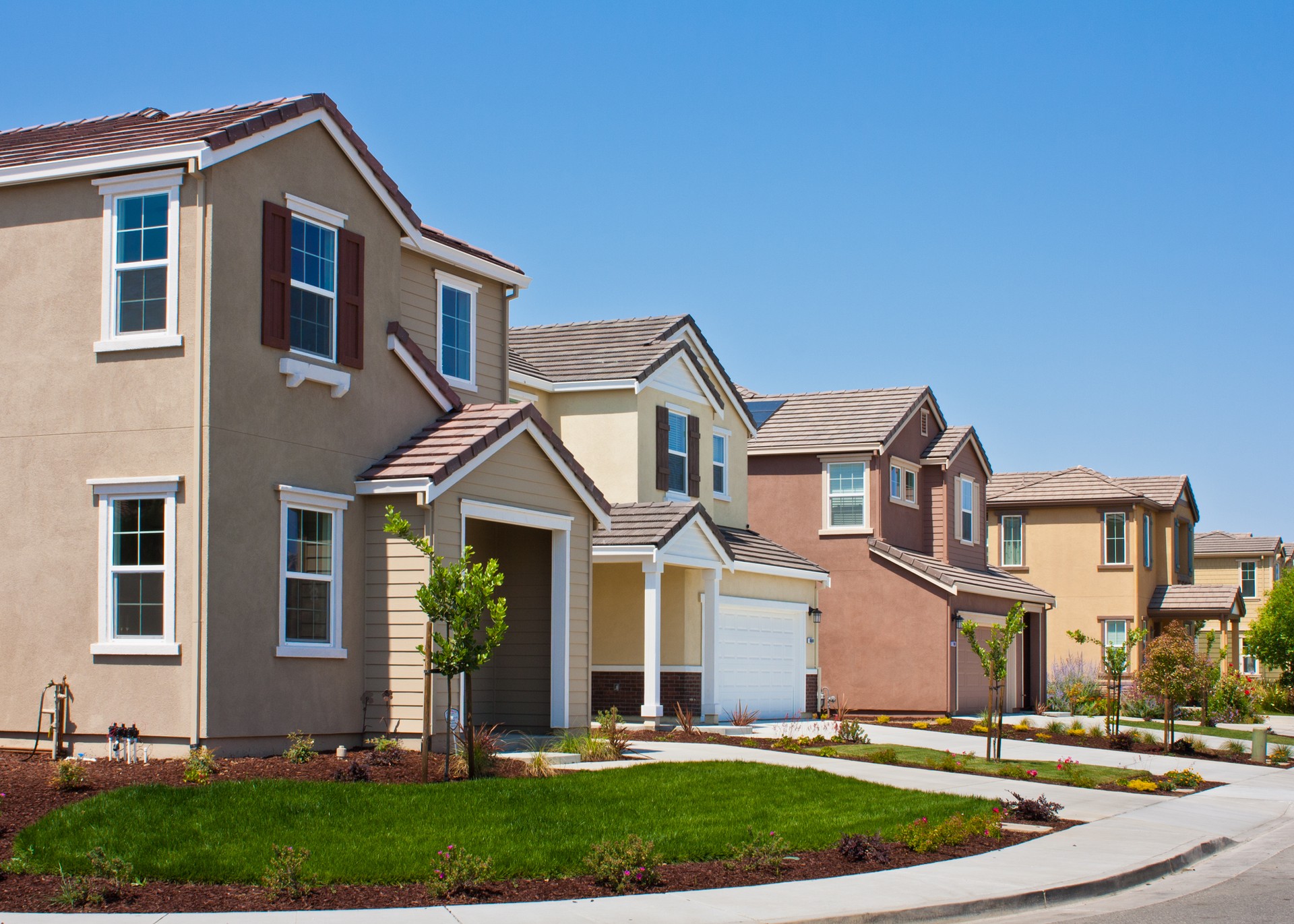 A street side view of four tract houses in a row