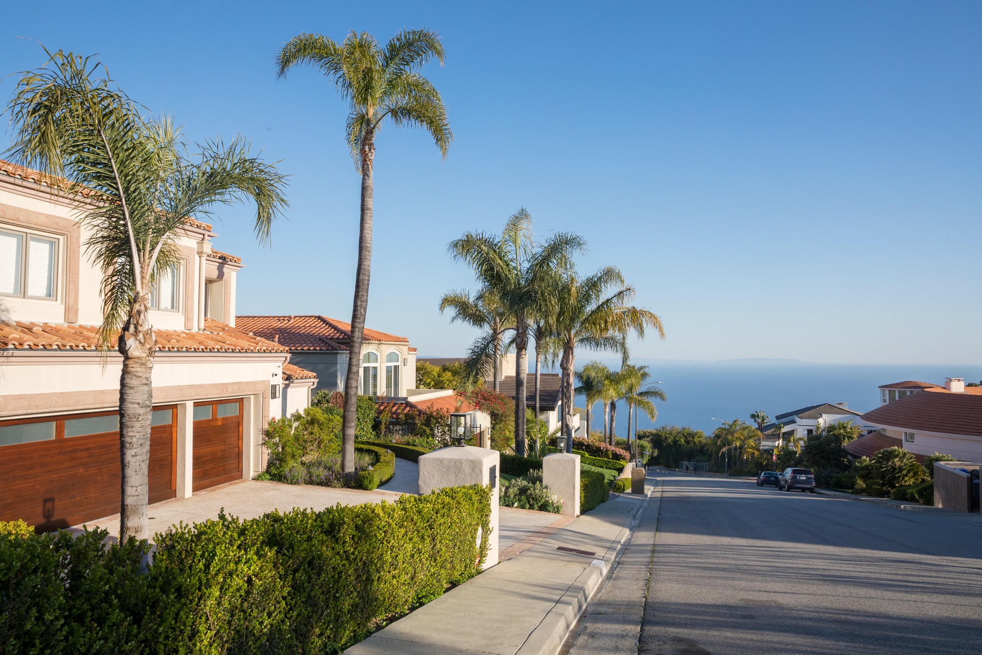 Pacific Palisades street with palm trees and ocean view. Southern California